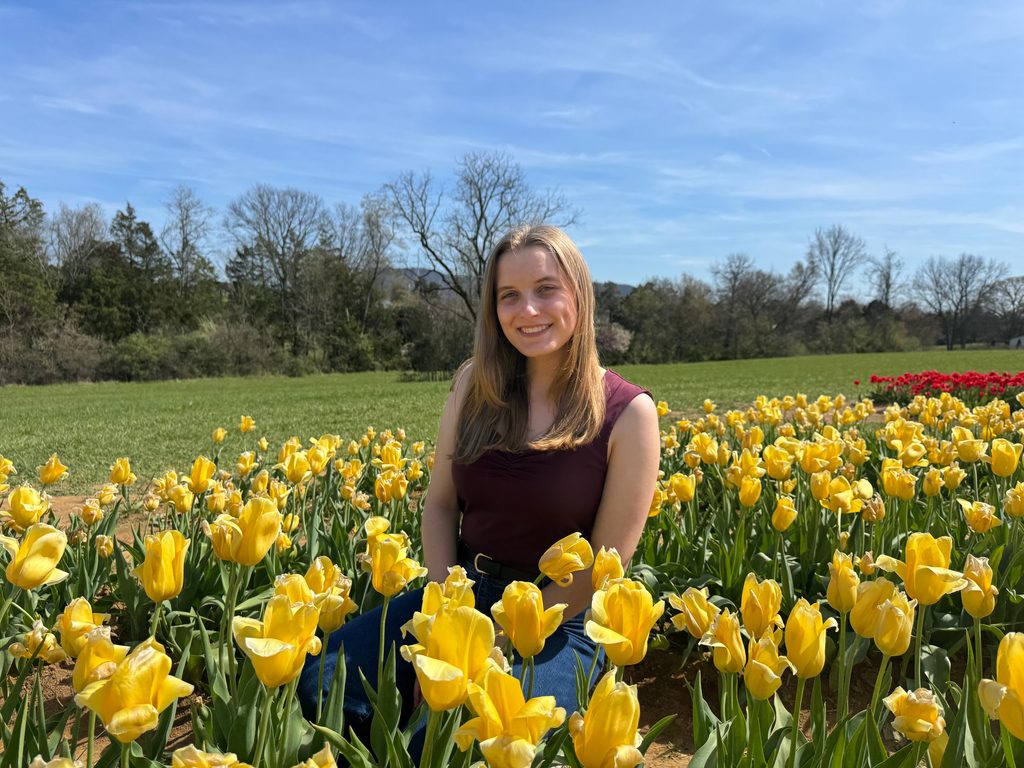 Emma Crooks in a field of yellow flowers.